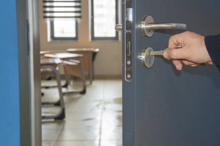 Person unlocking door to a school classroom