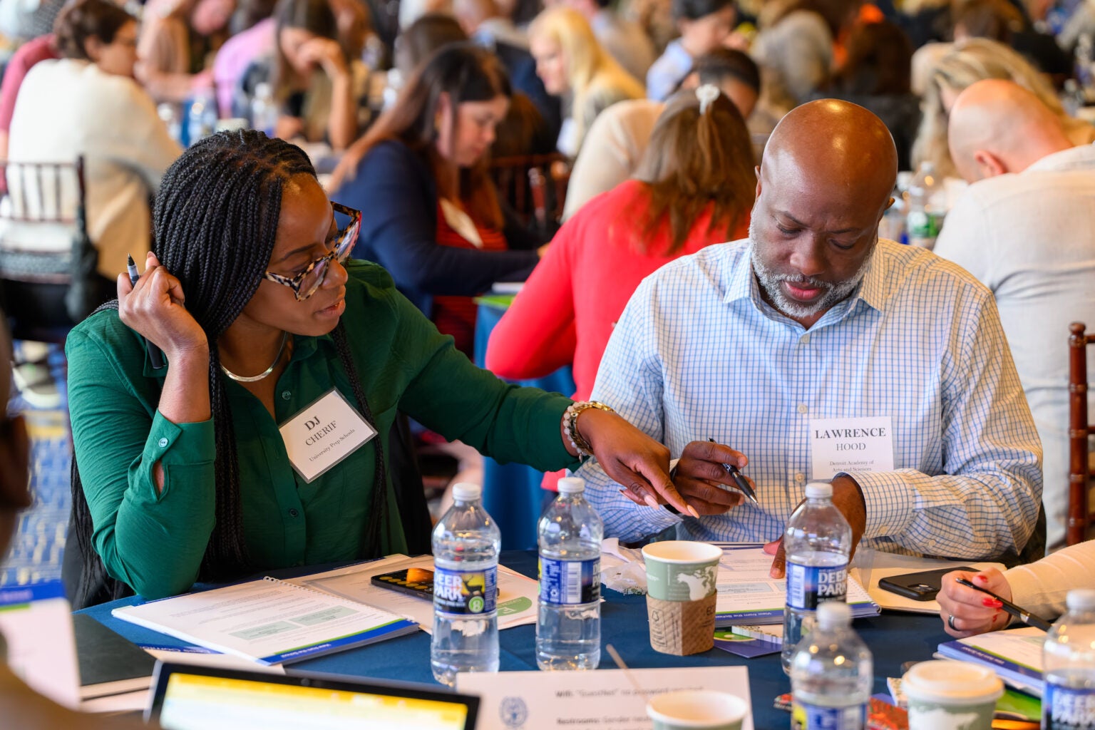 Two adults working through problem sets during certificate event